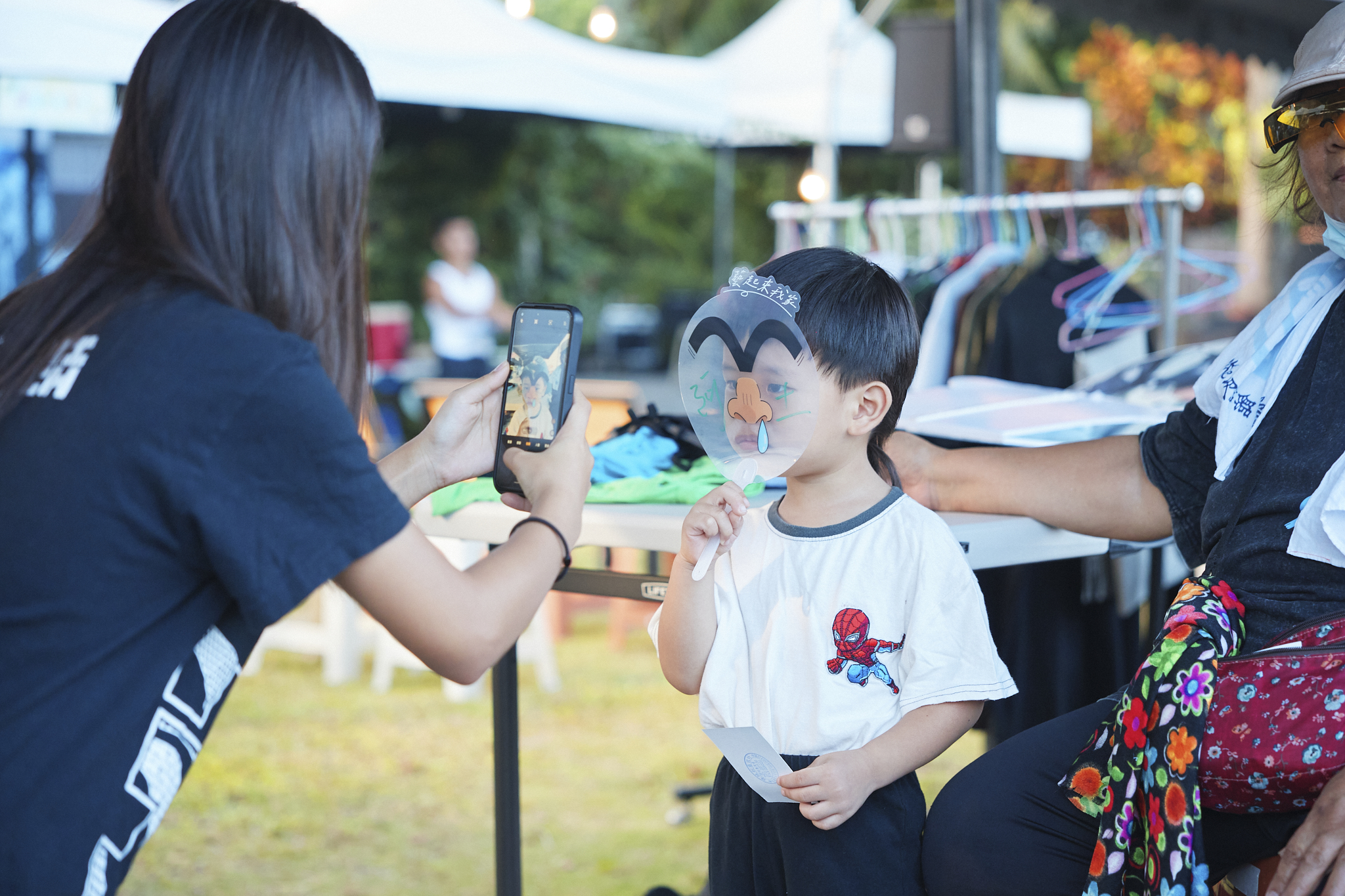 孩童手持活動風扇，留下逗趣的畫面~